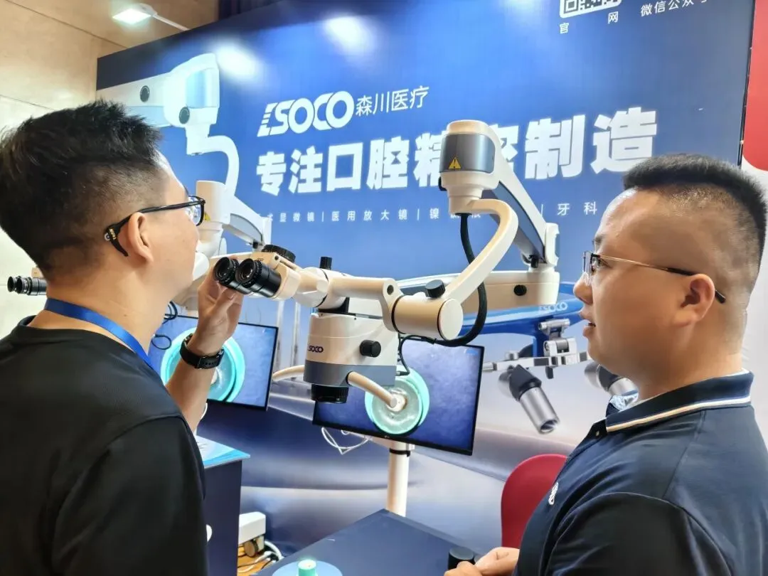 Dentists testing a SOCO dental operating microscope and dental loupes at the implant congress booth